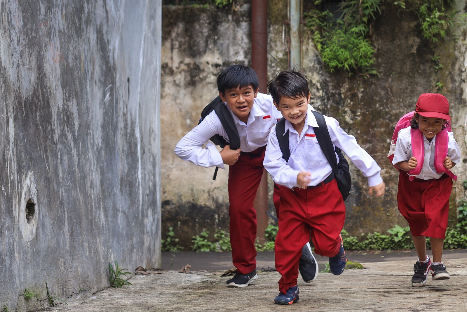 primary-school-kids-wearing-school-uniforms-backpacks-running-walkway